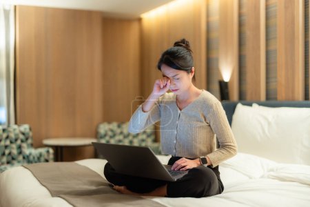 Foto de Mujer se siente pin en el ojo para el uso de ordenador portátil en la cama por la noche - Imagen libre de derechos
