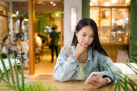 Photo for Woman use of cellphone in cafe - Royalty Free Image