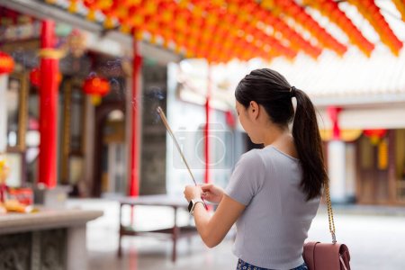 Téléchargez les photos : Femme asiatique allumant bâtons d'encens pour prier dans le temple chinois - en image libre de droit