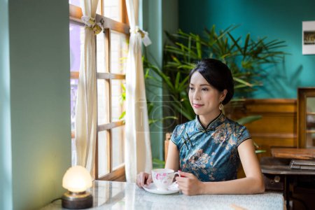 Téléchargez les photos : Femme porter cheongsam chinois traditionnel dans le restaurant vintage - en image libre de droit
