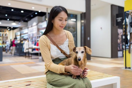 Photo for Woman go out with her dachshund dog at shopping mall - Royalty Free Image