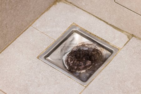 Foto de Bloqueado con sucio y pelo sobre tuberías de alcantarillado desagüe del piso en el baño - Imagen libre de derechos