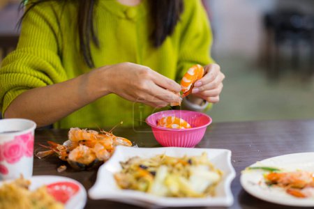 Foto de Mujer despegar camarones en el restaurante - Imagen libre de derechos