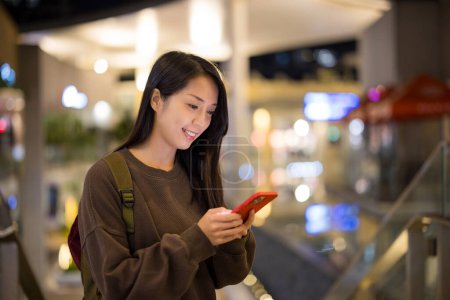 Téléchargez les photos : Femme utilisation du téléphone portable à l'extérieur le soir - en image libre de droit