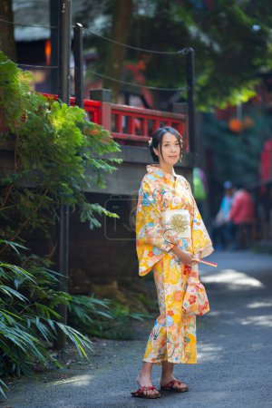 Foto de Mujer usar kimono amarillo en el pueblo japonés - Imagen libre de derechos