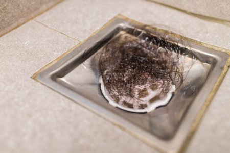 Foto de Bloqueado con sucio y pelo sobre tuberías de alcantarillado desagüe del piso en el baño - Imagen libre de derechos