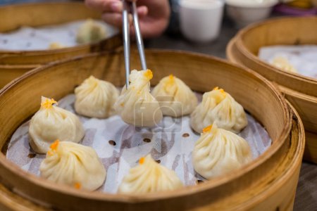 Photo for Steamed xiaolongbao served in a traditional steaming basket - Royalty Free Image
