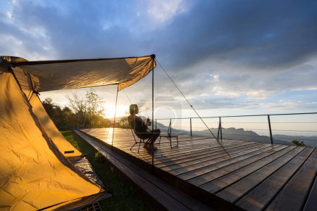 Téléchargez les photos : Femme aller camper et profiter de la vue sur le coucher du soleil - en image libre de droit