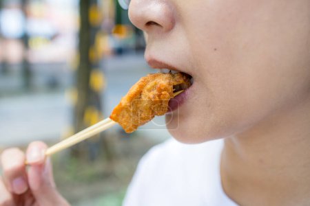 Téléchargez les photos : Femme manger avec un morceau de poulet croustillant - en image libre de droit