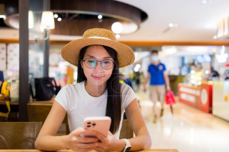 Téléchargez les photos : Femme utilisation du téléphone portable dans le restaurant - en image libre de droit