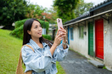 Woman use cellphone to take photo in Tourist attraction spot in Taipei city