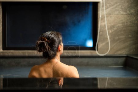 Téléchargez les photos : Femme profiter de l'onsen dans la baignoire à l'hôtel - en image libre de droit