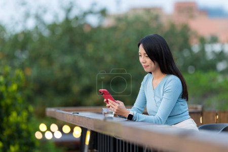 Foto de Mujer uso del teléfono móvil en la cafetería al aire libre - Imagen libre de derechos