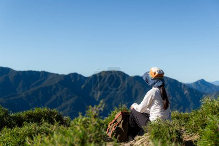 Foto de Caminata mujer sentarse en la cima de la montaña - Imagen libre de derechos