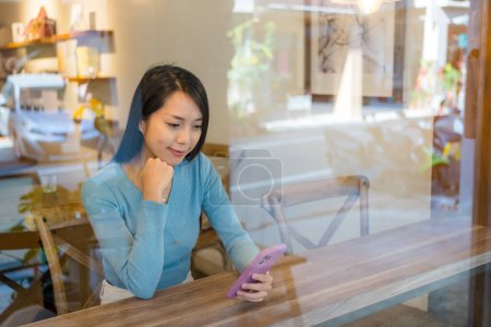 Téléchargez les photos : Femme regarder le téléphone intelligent dans le café - en image libre de droit
