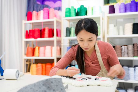 Foto de Mujer elegir el color del hilo para la fabricación de alfombras de mechón en el estudio - Imagen libre de derechos