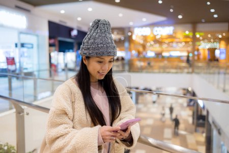 Téléchargez les photos : Femme utilisation de téléphone portable à l'intérieur du centre commercial - en image libre de droit