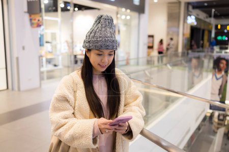 Foto de Mujer uso de teléfono móvil dentro del centro comercial - Imagen libre de derechos
