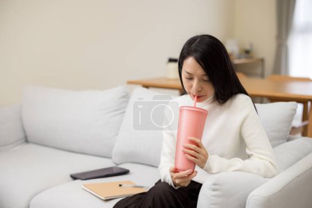 Téléchargez les photos : Femme boire une bouteille d'eau à la maison - en image libre de droit