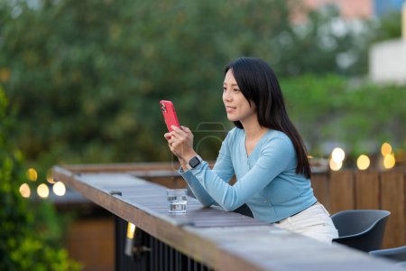 Téléchargez les photos : Woman use mobile phone at outdoor cafe - en image libre de droit