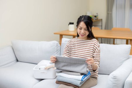 Téléchargez les photos : Pliage femme au foyer avec serviettes lavées à la maison - en image libre de droit