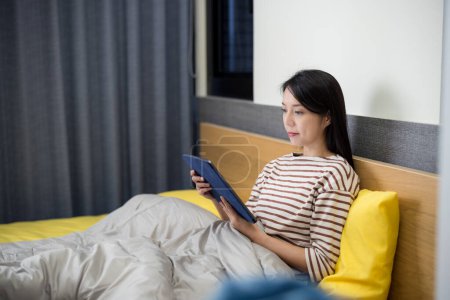 Foto de Mujer trabajo en tableta digital en la cama - Imagen libre de derechos