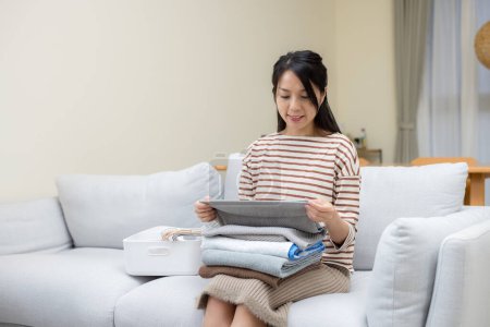 Téléchargez les photos : Pliage femme au foyer avec serviettes lavées à la maison - en image libre de droit