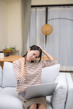 Téléchargez les photos : Femme souffrent du cou muscles tendus fatigués après avoir utilisé un ordinateur portable pendant si longtemps à la maison - en image libre de droit