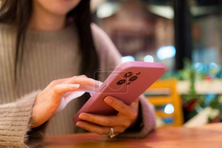 Téléchargez les photos : Femme tenir avec téléphone portable dans le restaurant - en image libre de droit