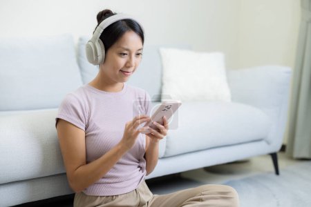 Woman listen to music and use of mobile phone at home