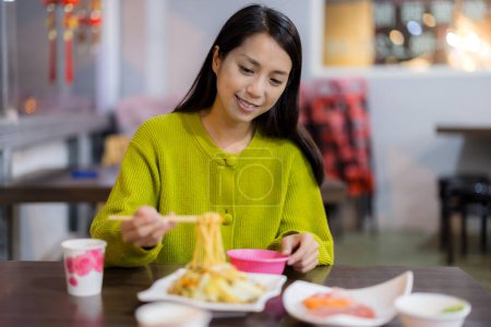 Téléchargez les photos : Femme manger avec des nouilles dans le restaurant taïwanais local de fruits de mer - en image libre de droit