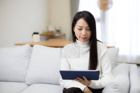 Téléchargez les photos : Femme lu sur tablette numérique à la maison - en image libre de droit