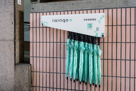 Foto de Taipei, Taiwán - 13 de diciembre de 2023: Paraguas compartidos "Raingo" colocados fuera de la estación MRT - Imagen libre de derechos