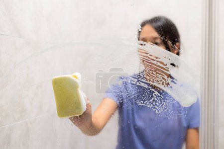 Foto de Mujer limpiar las manchas de agua dura y depósitos en el baño - Imagen libre de derechos