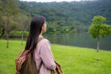 Téléchargez les photos : Femme profiter de la vue sur le lac à la campagne - en image libre de droit