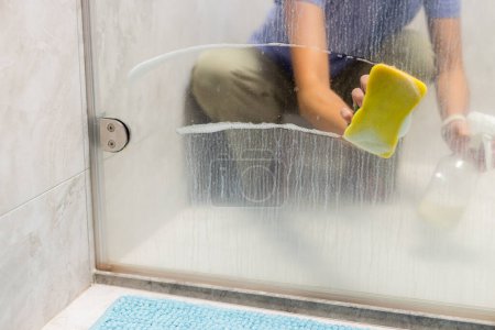 Photo for Polishing a glass shower doors at home - Royalty Free Image