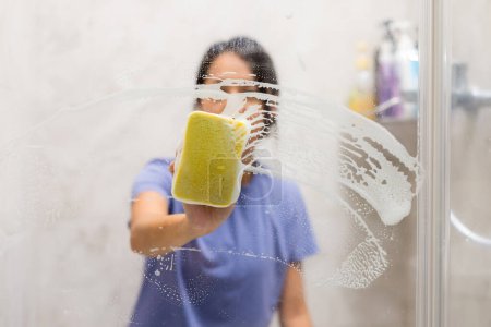 Foto de Mujer limpiar las manchas de agua dura y depósitos en el baño - Imagen libre de derechos