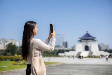 Mujer turística tomar una foto en el teléfono móvil en Chiang Kai shek Memorial Hall en Taipei de Taiwán