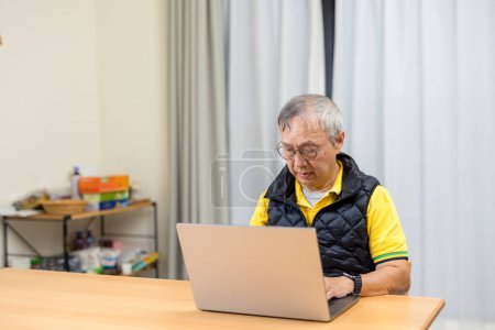 Photo for Asian man work on laptop computer at home - Royalty Free Image