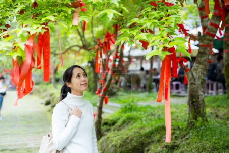 Téléchargez les photos : Asiatique femme faire un souhait et attacher le ruban overt l'arbre - en image libre de droit