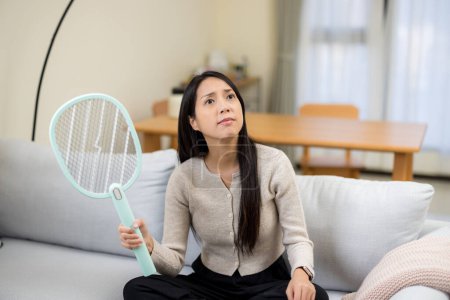 Woman use mosquito swatter at home