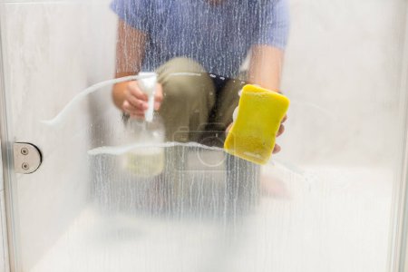 Foto de Las manos limpian ventanas con esponja y detergente - Imagen libre de derechos