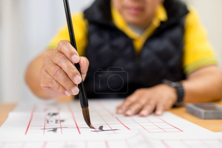 Téléchargez les photos : Asiatique vieil homme écrire calligraphie chinoise - en image libre de droit