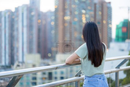 Photo for Woman look at the city in the evening - Royalty Free Image