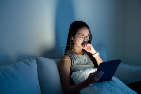 Téléchargez les photos : Femme avec des lunettes et souffrent de douleur oculaire avec l'utilisation d'une tablette numérique le soir à la maison - en image libre de droit