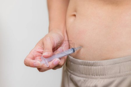 Téléchargez les photos : Femme injecte des hormones dans le ventre avec une seringue - en image libre de droit