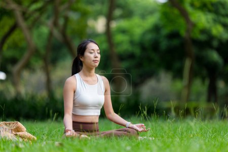 Téléchargez les photos : Femme faire de la méditation au parc - en image libre de droit