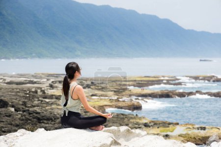 Téléchargez les photos : Femme faire des exercices de yoga au bord de la mer - en image libre de droit