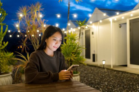 Téléchargez les photos : Femme utiliser le téléphone mobile en ville à l'heure du soir - en image libre de droit