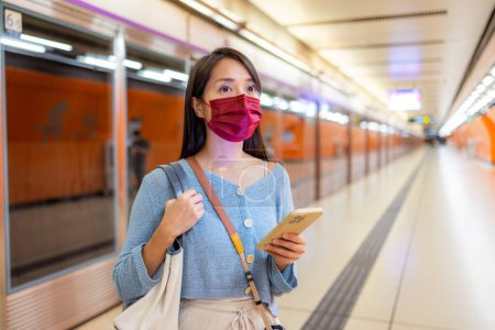 Mujer usar mascarilla en la estación de metro en la ciudad de Hong Kong